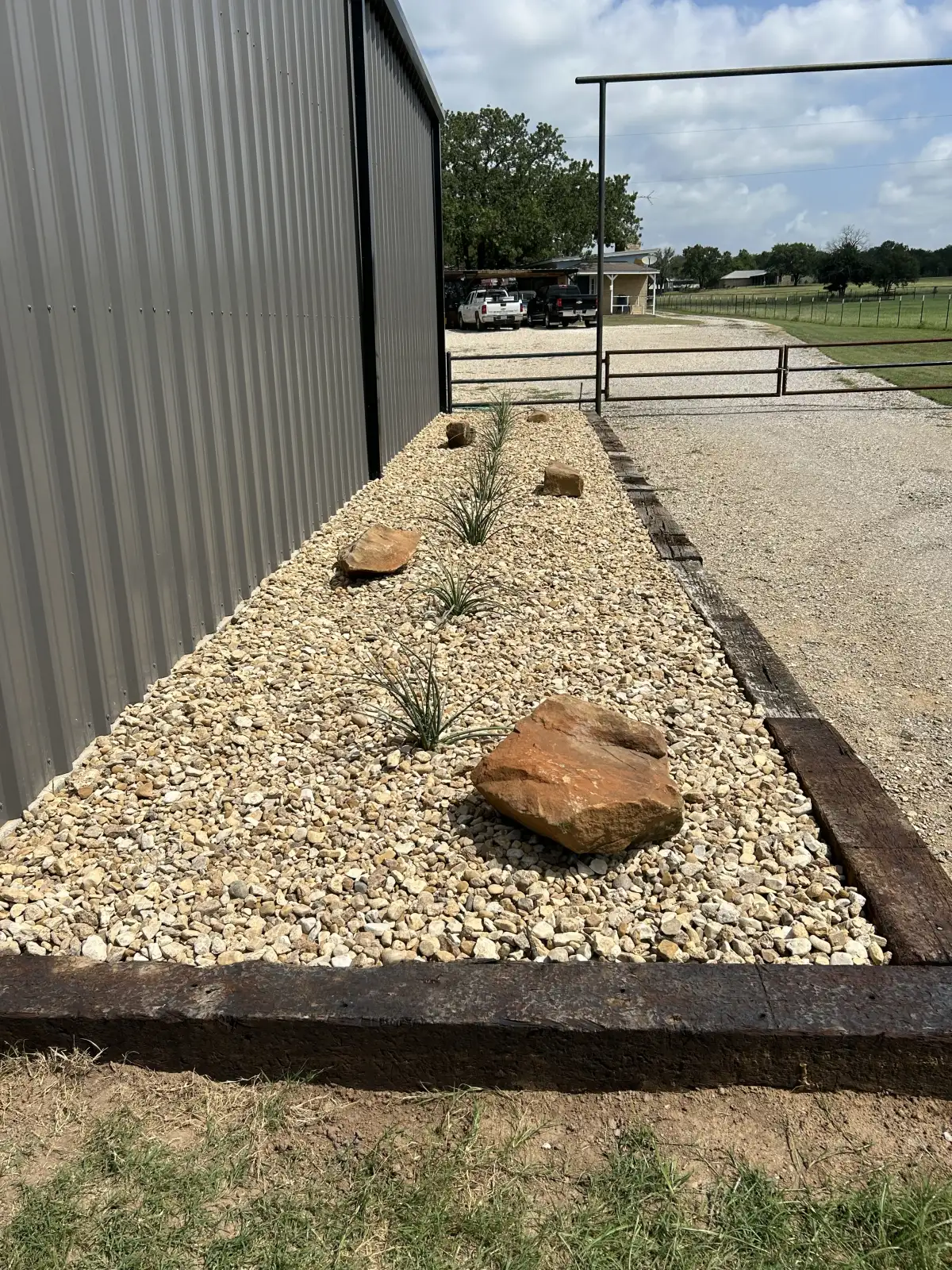 Rock and gravel hardscape bed with natural boulders in Weatherford TX