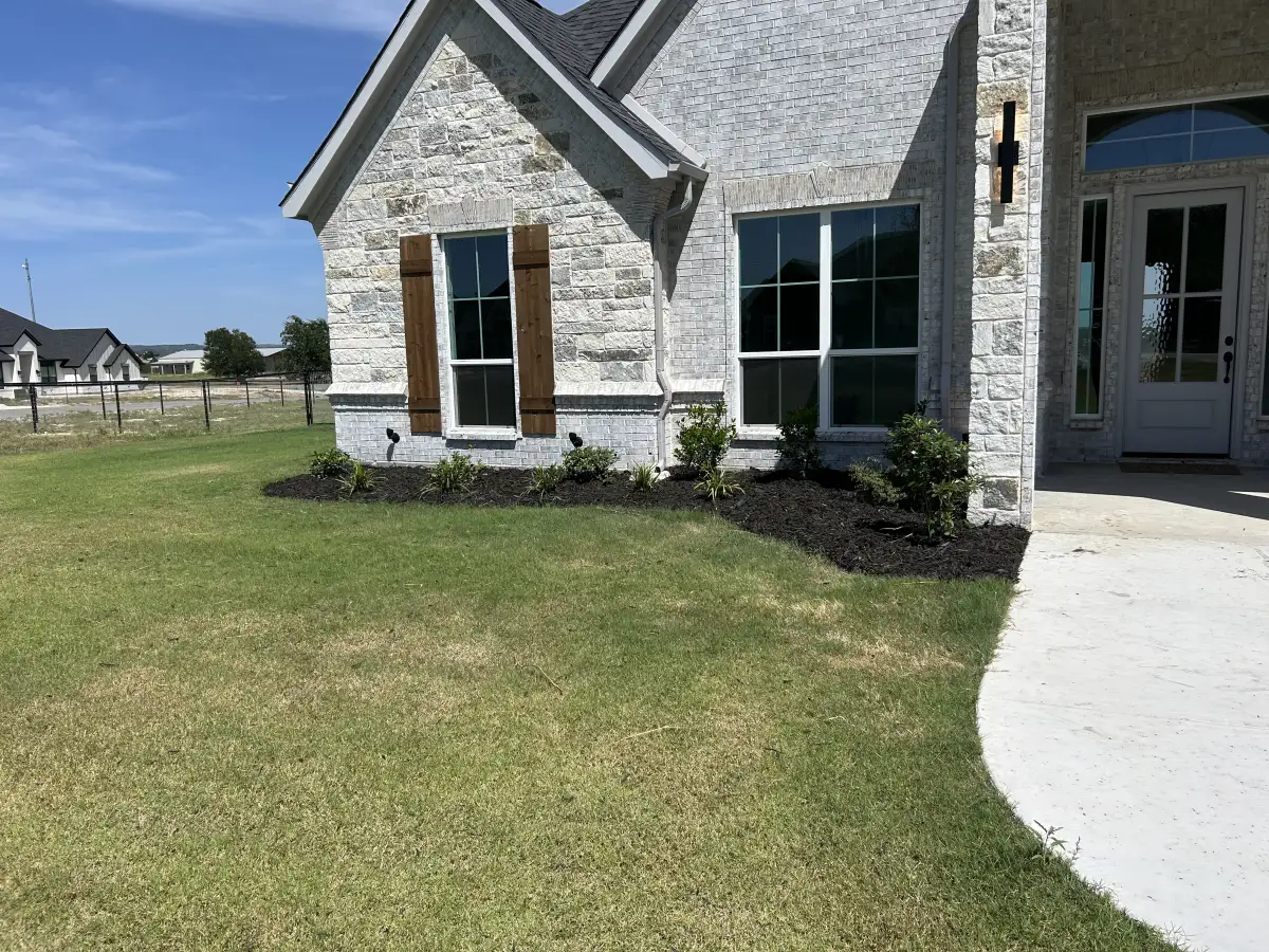 Luxury landscape design with mulch beds and plantings at a Weatherford TX home